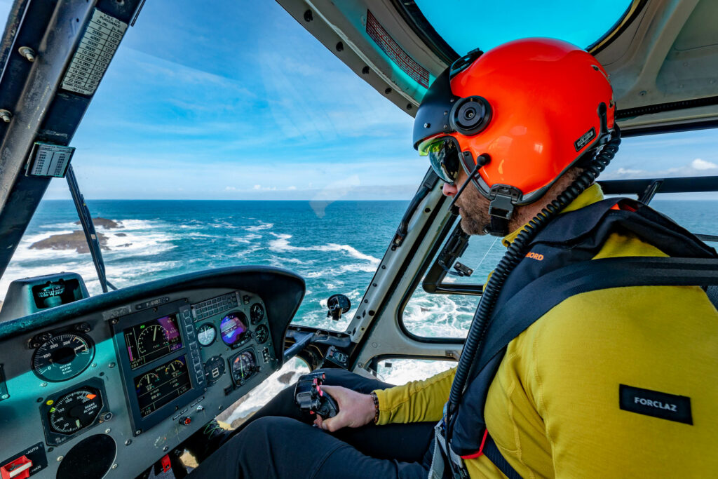 Un pilote dans son hélicoptère survol l'océan.