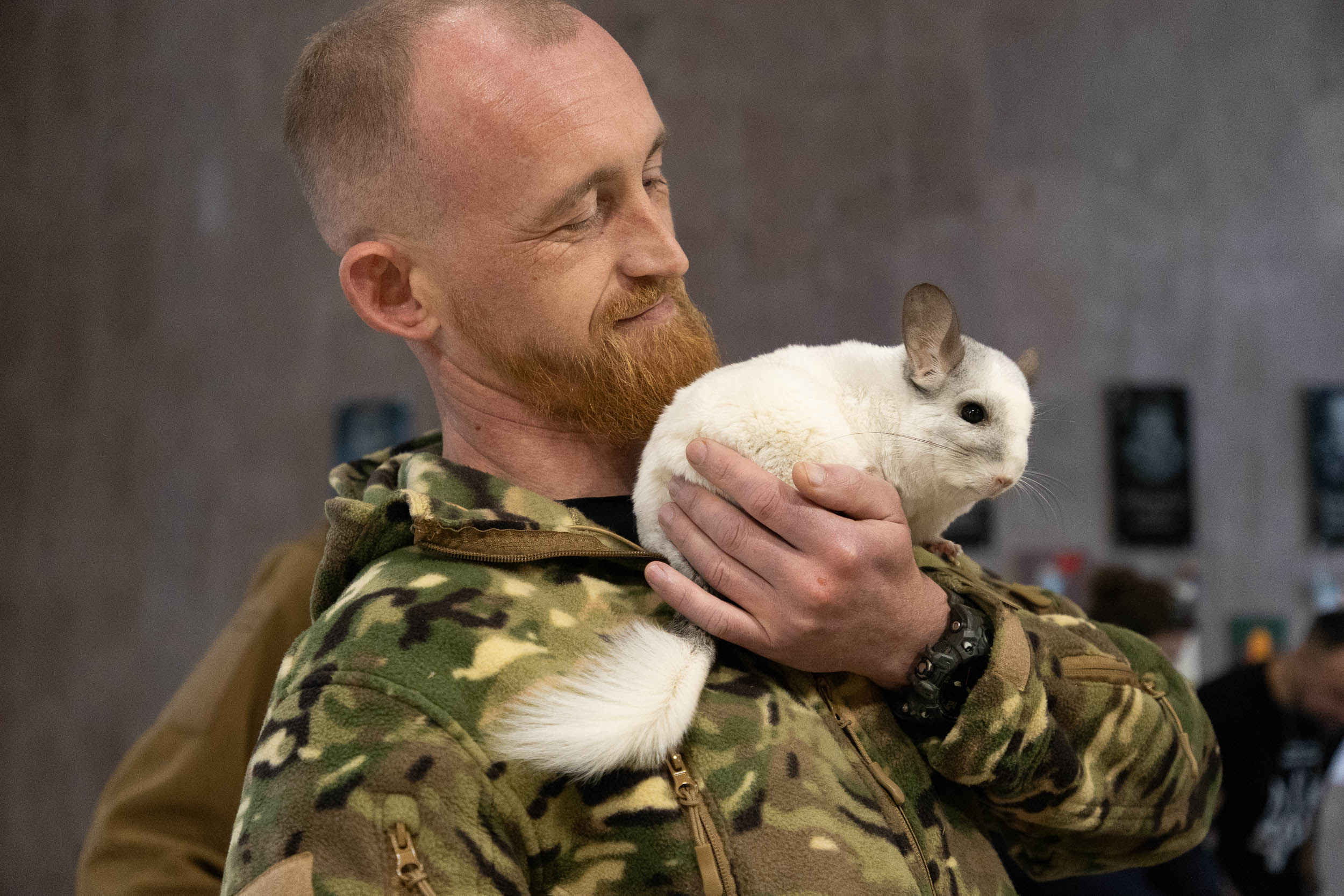 Un militaire Ukrainien, après avoir vécu l'horreur sur la ligne de front, se réconforte avec un petit mammifère apporté par le zoo de Kyiv.